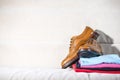 Pair of Male Full Brogued Tan Oxford Shoes Placed on Top of Heap Of Colorful Clothing