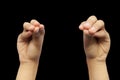 Pair of male hands doing Mukula Mudra isolated on a black background.