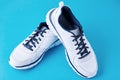 Pair of male white sneakers on a blue background. Sport shoe close up Royalty Free Stock Photo