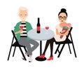 Pair of man and woman dressed in elegant clothing sitting at table and drinking red wine. Couple on romantic date or Royalty Free Stock Photo