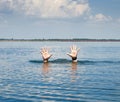 pair of masculine hands sticks out of the sea water on a summer day