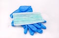 Pair of medical blue latex protective glove and green mask on white background. Protection equipment against virus, flu. Royalty Free Stock Photo