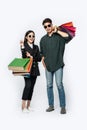 A pair of men and women wore glasses and carried lots of paper bags for shopping