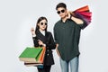 A pair of men and women wore glasses and carried lots of paper bags for shopping