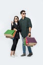 A pair of men and women wore glasses and carried lots of paper bags for shopping