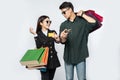 A pair of men and women wore glasses and carried lots of paper bags for shopping