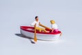 Miniature Figures Rowing In A Boat 