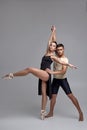 Two athletic modern ballet dancers are posing against a gray studio background. Royalty Free Stock Photo