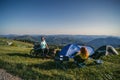 A pair of motorcyclists, man and woman. Loving couple of tourists. Relationship and adventure concept. A touring motorcycle, tent