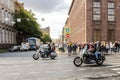 A pair of motorcyclists pass by spectators