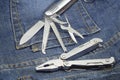 Pair multi kit hardware knife screwdriver metal tool close up on denim overalls worker