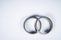 A pair of needle-bearing roller bearings on a gray background. The concept of new car parts