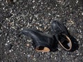 A pair of new black color boots shoes on the black rock beach Royalty Free Stock Photo