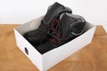 Pair of new black work boots made of genuine leather in a cardboard box, the concept of special shoes for different professions Royalty Free Stock Photo