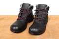 Pair of new black work boots made of genuine leather with a reinforced cape, the concept of special shoes for different