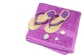 A pair of new, lilac women slippers for the beach and a towel