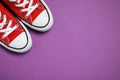 Pair of new stylish red sneakers on purple background, flat lay. Space for text Royalty Free Stock Photo