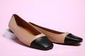 Pair of new stylish square toe ballet flats on pale pink background