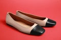 Pair of new stylish square toe ballet flats on red background