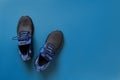 Pair of new textile sneakers over blue background. Black blue sport shoes with laced fastening close-up. Fabric mesh sneakers for Royalty Free Stock Photo