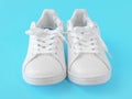 Pair of new white sneakers on blue background. New white leather sneakers sports shoes. sports shoes for running, tennis, jogging
