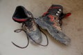 Pair of old black work boots made of genuine leather with torn laces lying on a dirty floor, the concept of special shoes for Royalty Free Stock Photo