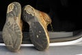 Pair of old brown hiking shoes on a car boot. Reliable leather worn out boots. Long walk or travel trip concept. Black sole with Royalty Free Stock Photo