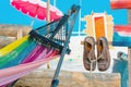 Pair of old brown leather shoes tied together with shoelaces hanging at the old vintage wooden pole at the sandy beach. Used Royalty Free Stock Photo