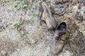 Pair of old dirty used shoes. Abandoned discarded boots laying in dust on ground. Poverty or beggary concept. Copyspace