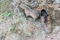 Pair of old dirty used shoes. Abandoned discarded boots laying in dust on ground. Poverty or beggary concept. Copyspace