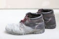 Pair of old dirty work boots in building site Royalty Free Stock Photo