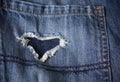 Pair of old jeans with heart shaped rip Royalty Free Stock Photo