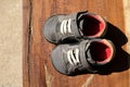 A pair of old shoes a brown wooden board. Royalty Free Stock Photo