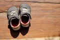 A pair of old shoes a brown wooden board. Royalty Free Stock Photo