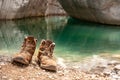 Pair of old tourists boots close up near the water. Royalty Free Stock Photo