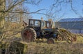 A Pair of Old unused Tractors, parked up in light Woodland next to a Modern barn at a Farm at the Mains of Arbilot. Royalty Free Stock Photo
