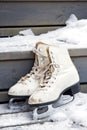 Pair of old white skates on snowy stairs