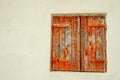 Pair of, old, wood, closed, window shutters, with peeling, red paint Royalty Free Stock Photo