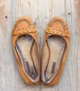 A pair of old worn orange female shoes made of genuine leather on old gray wooden board Royalty Free Stock Photo