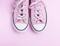 Pair of old worn pink sneakers with white laces