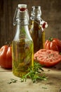 Pair of olive oil jars with rosemary and tomatoes