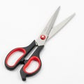 Open Pair of Scissors with Red and Black Handles on a White Background Royalty Free Stock Photo