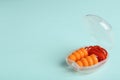 Pair of orange ear plugs with cord in case on turquoise background. Space for text Royalty Free Stock Photo