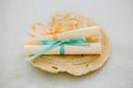 Pair of paper roll parchments tied with ribbon on a seashell, love messages