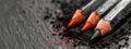 A pair of pencils atop a mound of black and red crayons Royalty Free Stock Photo