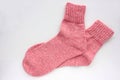 Pair of pink knitted socks on white background. Overhead view. Copy space