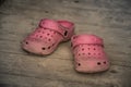 Pair of pink slippers abandoned on a wooden pier