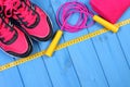 Pair of pink sport shoes and accessories for fitness on blue boards background, copy space for text Royalty Free Stock Photo