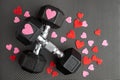 Pair of 15-pound dumbbells on a black gym floor, red and pink sparkly hearts