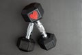 Pair of 15-pound dumbbells on a black gym floor, red sparkly heart